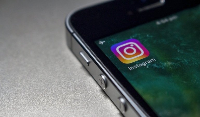Close-up of a smartphone with the Instagram icon on the screen.