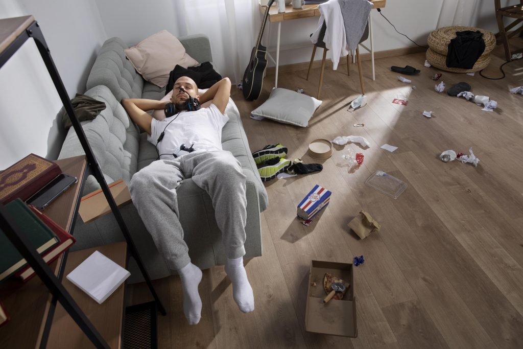 bad tenant enjoys on a bed while the rental unit is messy